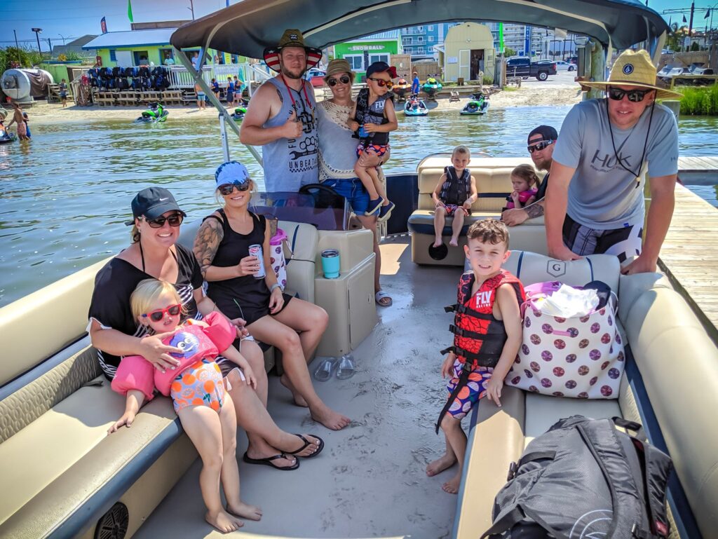 A family sitting on a pontoon boat at Odyssea Watersports
