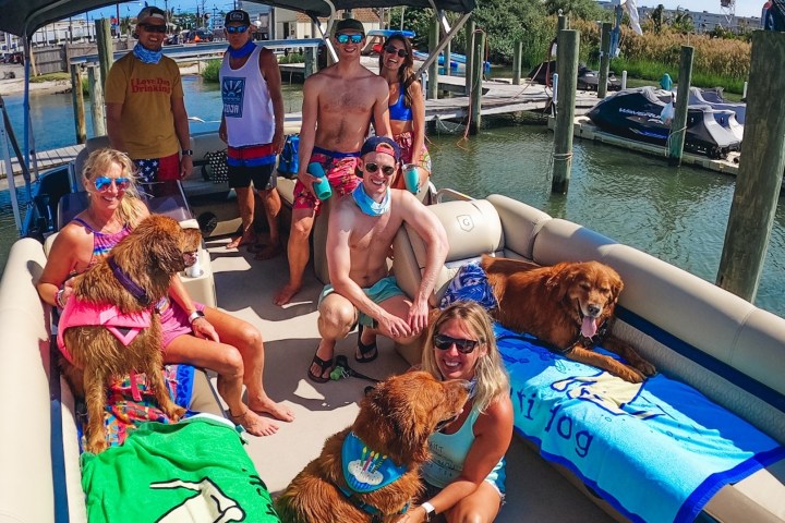 a person sitting on a boat with a dog in a pool of water